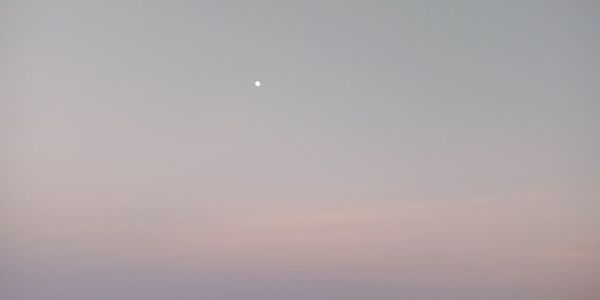 Low angle view of moon against sky at sunset