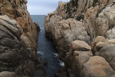 Rocks by sea against sky