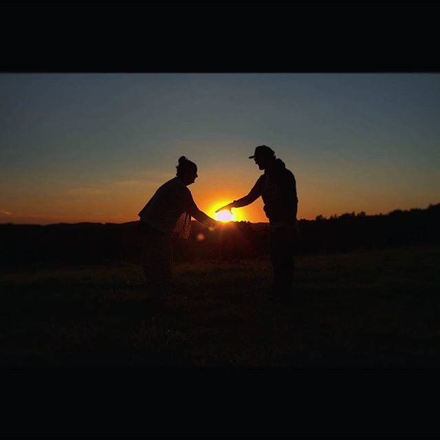 sunset, silhouette, sun, orange color, lifestyles, men, leisure activity, standing, copy space, clear sky, landscape, sunlight, sky, back lit, field, side view, outline, full length