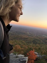 Side view of young woman looking at sunset