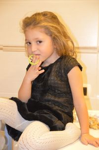 Portrait of girl sitting on table at home