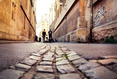 People walking on footpath amidst buildings in city