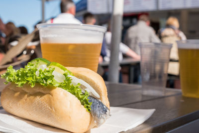 Close-up of sandwich by beer on table