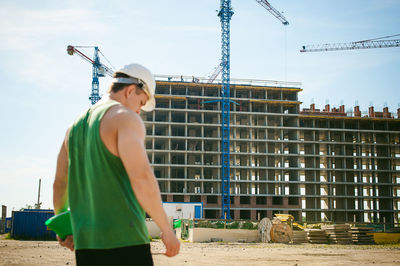 Man standing against construction buildings