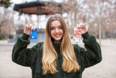 Portrait of smiling young woman holding ice cream