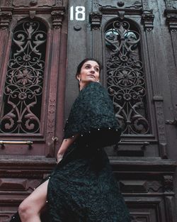 Portrait of woman standing at entrance of building