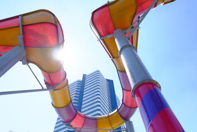 Low angle view of colorful slide against clear sky during sunny day