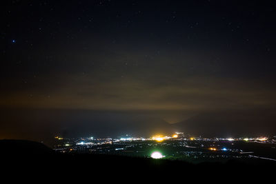 Illuminated city against sky at night