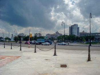 Buildings by street against sky in city