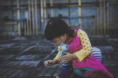 Cute girl playing while crouching on street