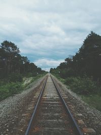 Railroad tracks amidst trees against sky