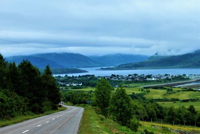 Road leading towards mountains against sky