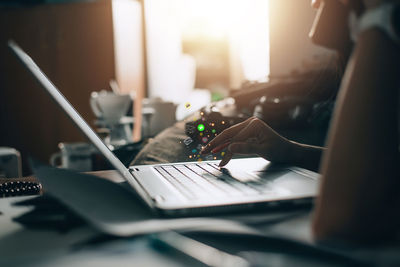 Midsection of woman using laptop on table