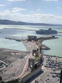 High angle view of city by sea against sky