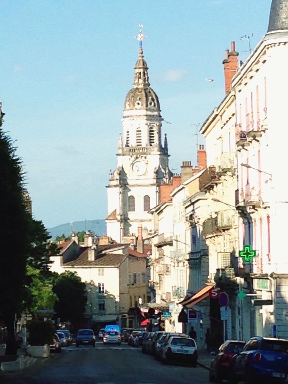 building exterior, architecture, built structure, car, land vehicle, church, transportation, religion, street, place of worship, mode of transport, city, clear sky, spirituality, tower, road, incidental people, travel