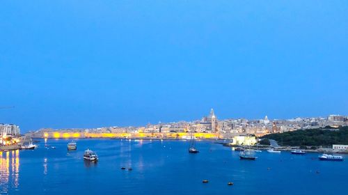 Sailboats in sea against clear blue sky