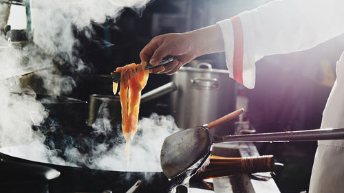 Chef stir fry busy cooking in kitchen. chef stir fry the food in a frying pan