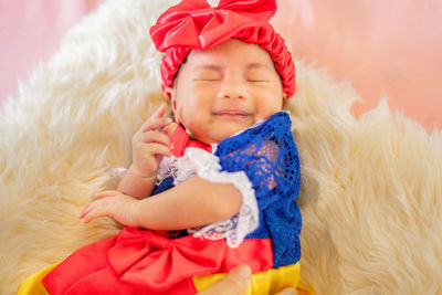 Portrait of cute baby girl lying on bed