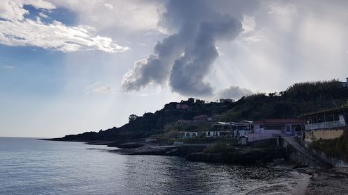 Panoramic view of sea and buildings against sky