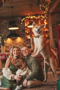 Candid authentic happy family during wintertime together enjoying holidays with dog at xmas