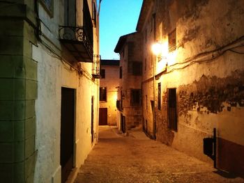 Illuminated amidst buildings against sky