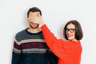 Portrait of young couple standing against white background