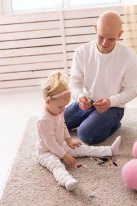 Portrait of siblings sitting on floor at home