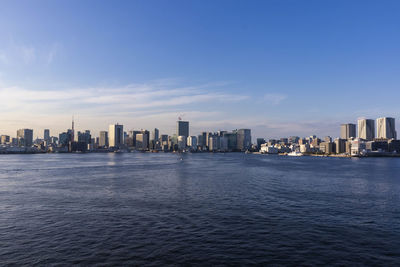 Sea by buildings against sky in city