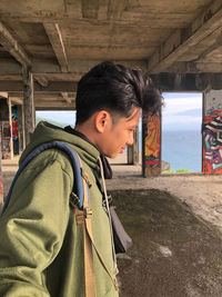 Side view of young man standing at temple