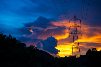 Low angle view of silhouette electricity pylon against romantic sky