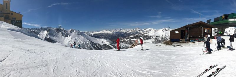 People on snowcapped mountain against sky