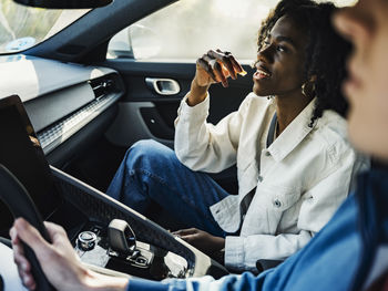 Woman having candy sitting with friend in car