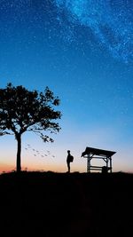 Silhouette man on field against sky at night