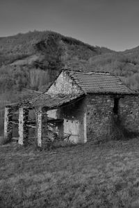 Old abandoned house on field against sky