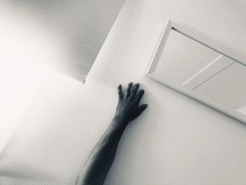 High angle view of hand touching wall at home