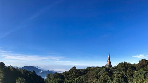 Panoramic view of trees and mountains against blue sky