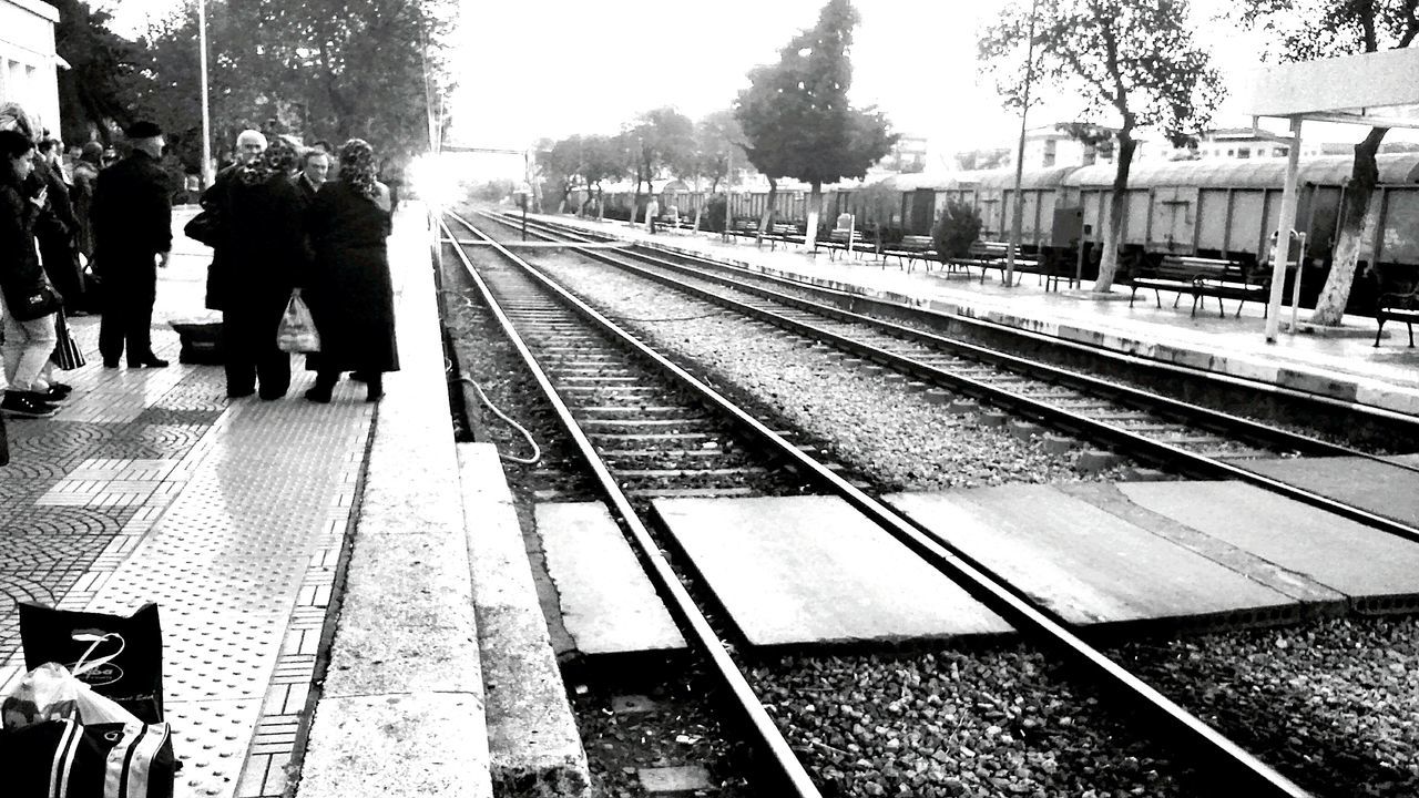 railroad track, rail transportation, railroad station platform, public transportation, transportation, railroad station, men, person, lifestyles, travel, incidental people, tree, walking, city life, high angle view, city, day, outdoors