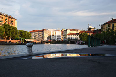 River by buildings in city against sky