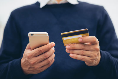 Midsection of man using mobile phone