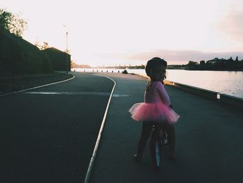 Portrait of cute girl sitting on bicycle against clear sky