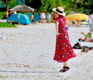 Woman with umbrella standing on beach