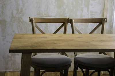 Empty chairs and table against wall at home