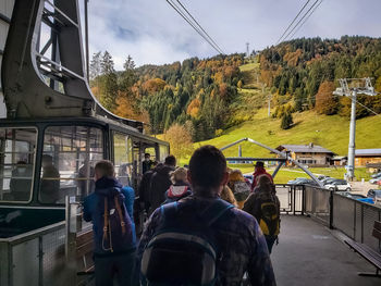 Rear view of people traveling in train against sky