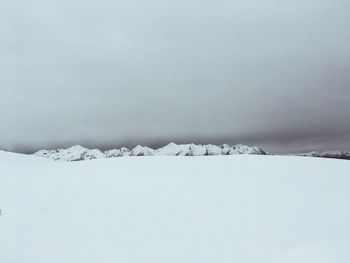 Snow covered landscape against sky