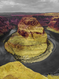 Aerial view of rock formations against cloudy sky