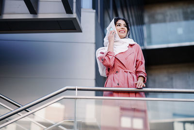 Low angle view of woman standing against railing