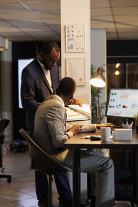 Portrait of businessman using laptop at office