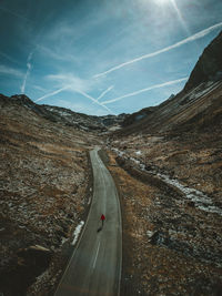 Aerial view of road by mountains against sky