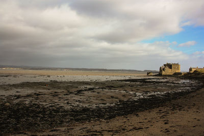 View of beach against cloudy sky