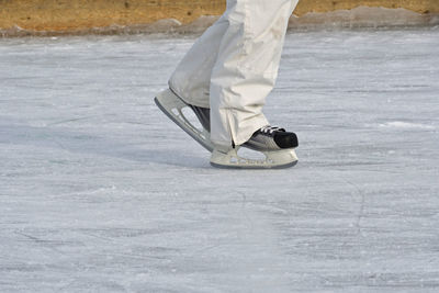 Low section of person ice-skating on ice rink during winter